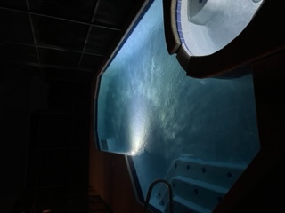 Illuminated hot tub at night with LED lighting and surrounding deck furniture