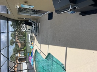 Residential pool area with screened enclosure, lounge chairs, and lanai deck