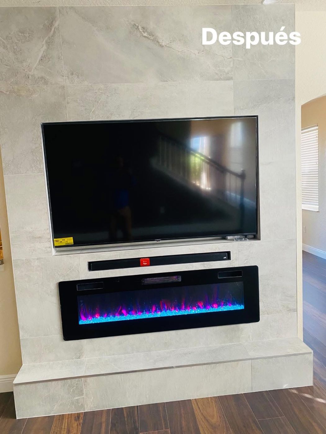 Modern fireplace with mounted TV and electric flame insert after renovation