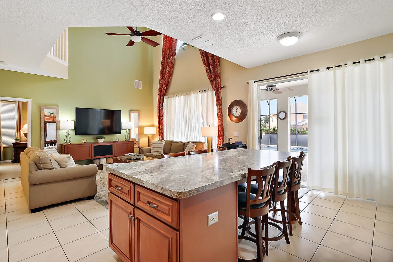 Open concept kitchen and living room with island, granite countertops, and large windows