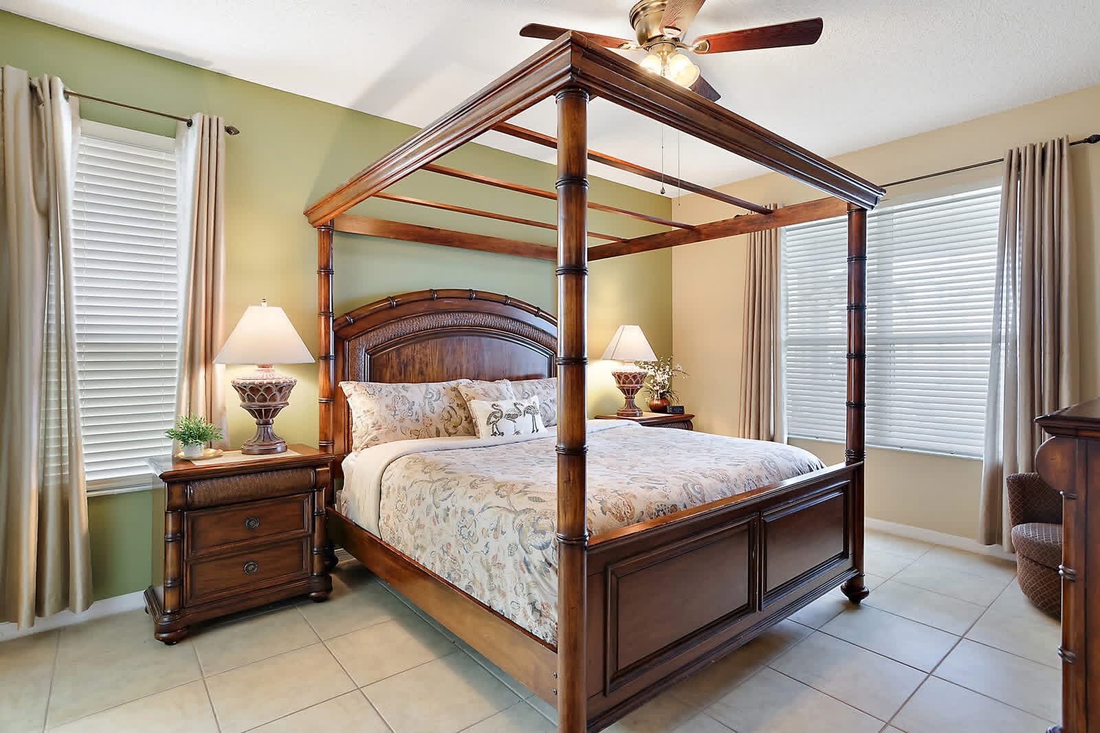 Spacious master bedroom with wooden four-poster canopy bed and matching nightstands